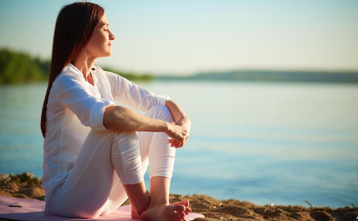 Woman relaxing by serene waters: A peaceful lakeside retreat.