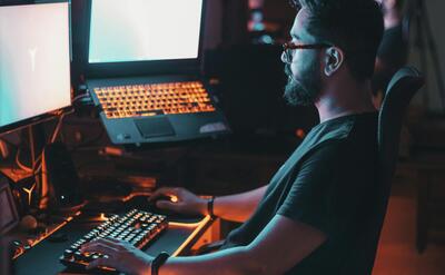 man in blue shirt using computer